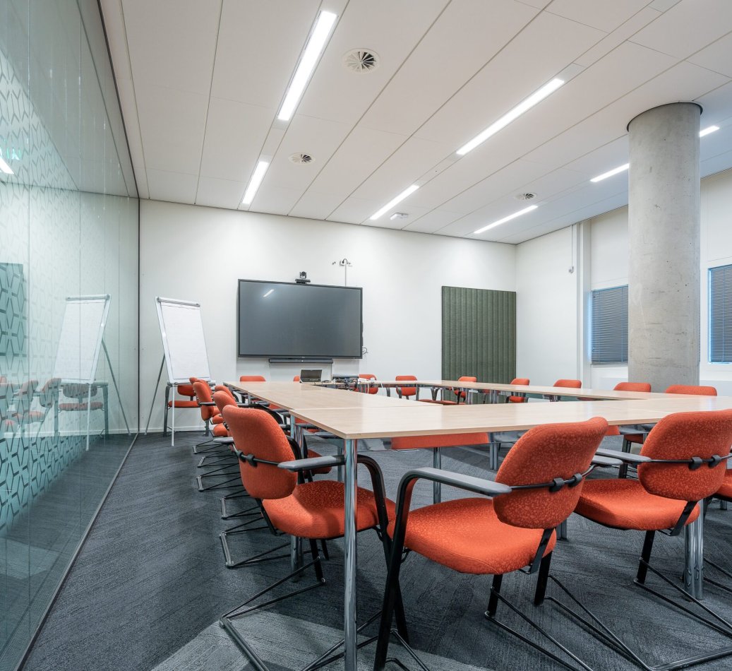 The conference room interior of a modern office with white walls and a monitor